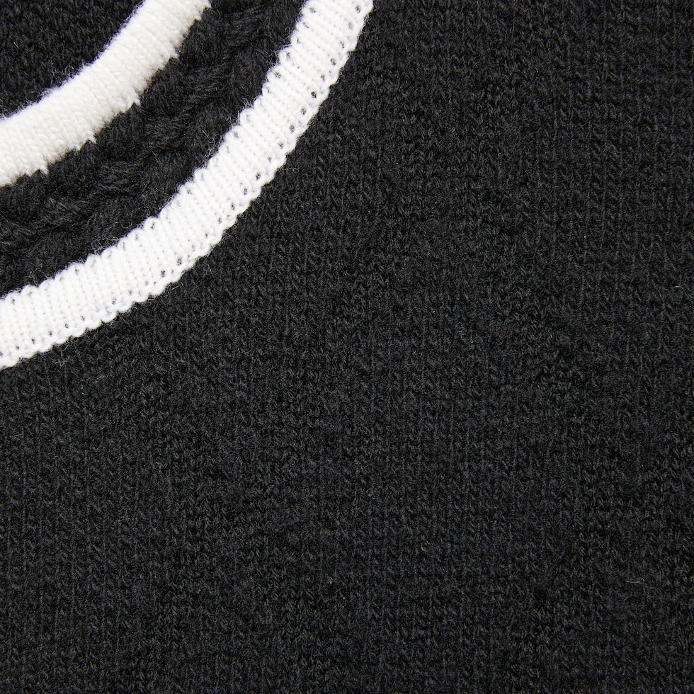 Close-up of a black sweater with white ribbed trim
