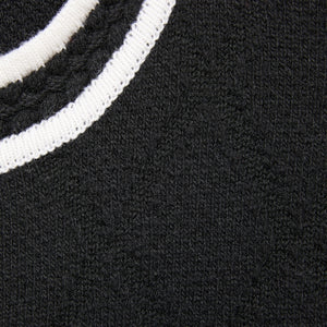 Close-up of a black sweater with white ribbed trim