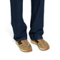 Beige sneakers with colorful accents worn with blue jeans on a white background