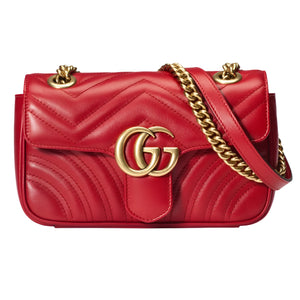 Red quilted handbag with gold chain andGG logo on a light gray background