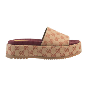 Beige and brown slide sandal with Gucci logo pattern on a light gray background