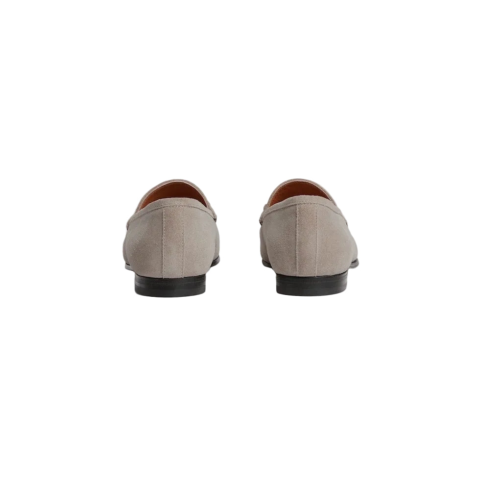 Pair of beige loafers on a light gray background