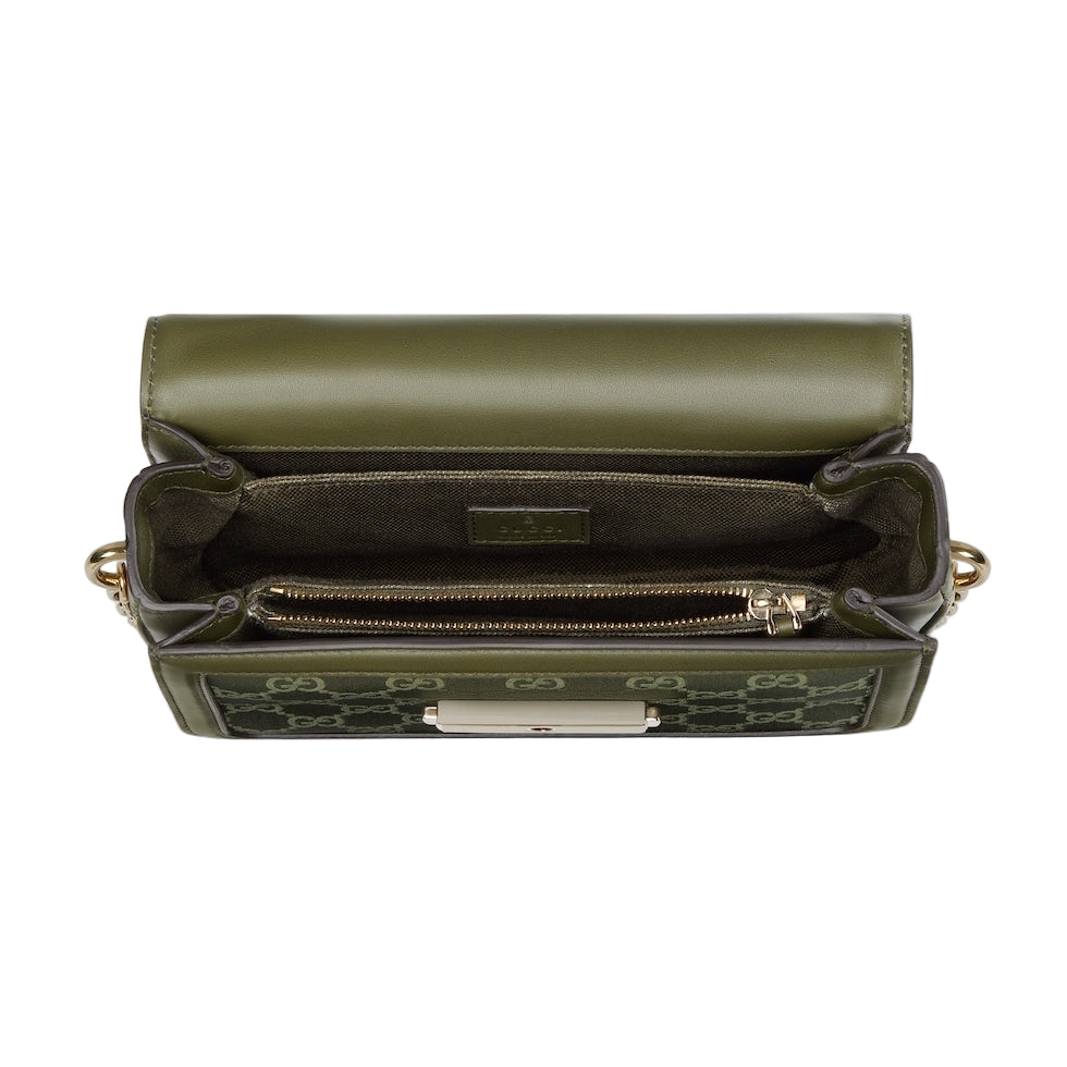 Green handbag with gold accents on a light gray background