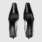 Black high-heeled shoes with Gucci branding on a white background