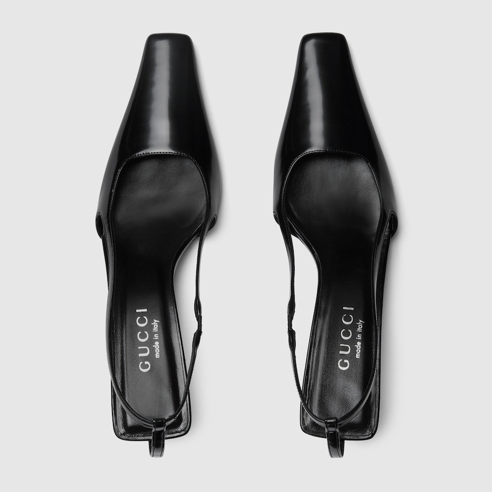 Black high-heeled shoes with Gucci branding on a white background