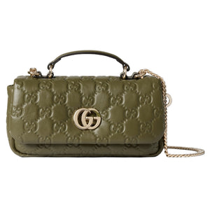 Green handbag with gold chain and logo on a light gray background