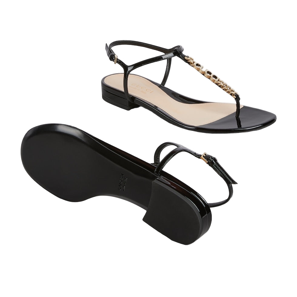 Black Gucci sandals with thin straps on a light gray background