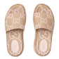 Beige Gucci slides with logo pattern on a light gray background