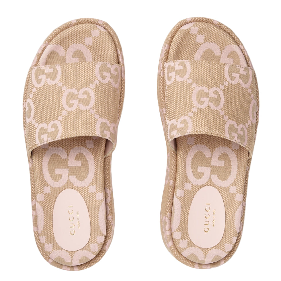 Beige Gucci slides with logo pattern on a light gray background