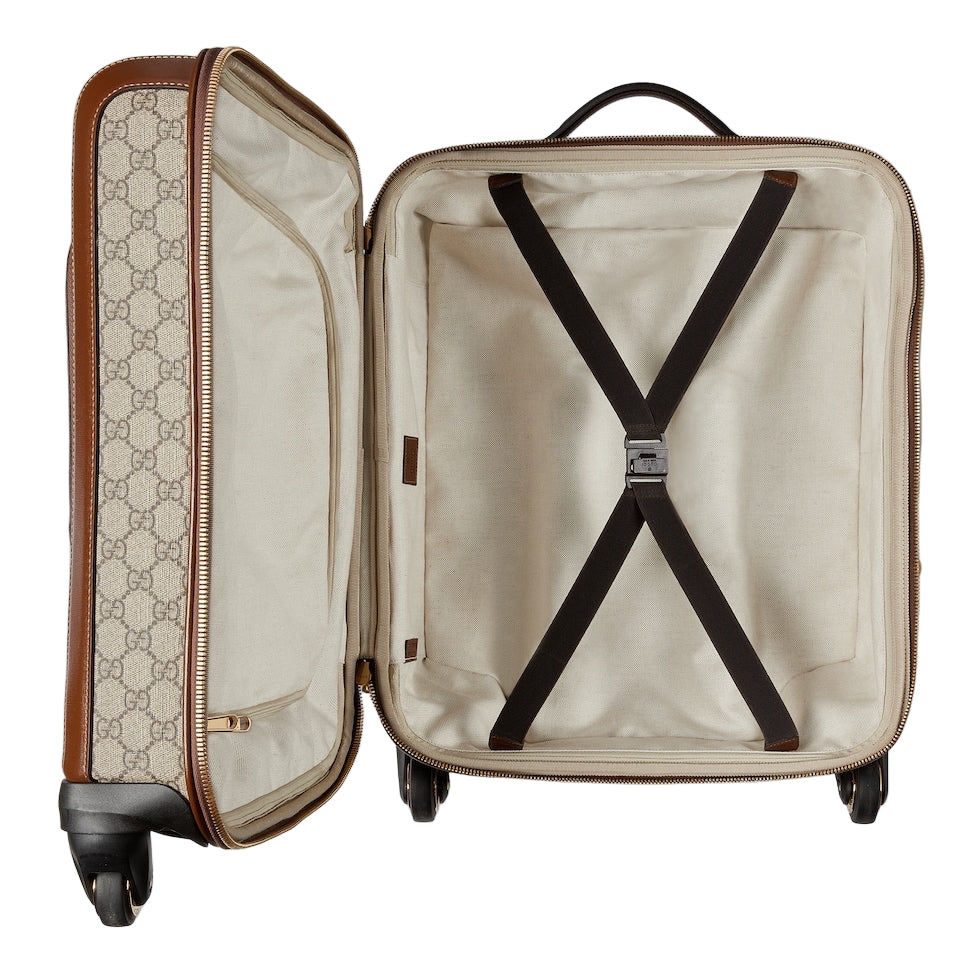 Open suitcase with Gucci pattern on a white background