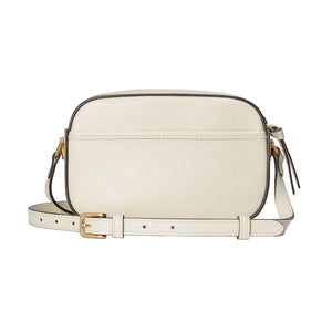 White handbag with gold accents on a light gray background