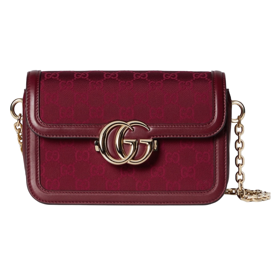 Red handbag with gold chain and logo on a light gray background
