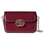 Red handbag with gold chain and logo on a light gray background