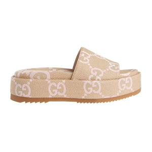 Beige slide sandal with Gucci logo on a light gray background