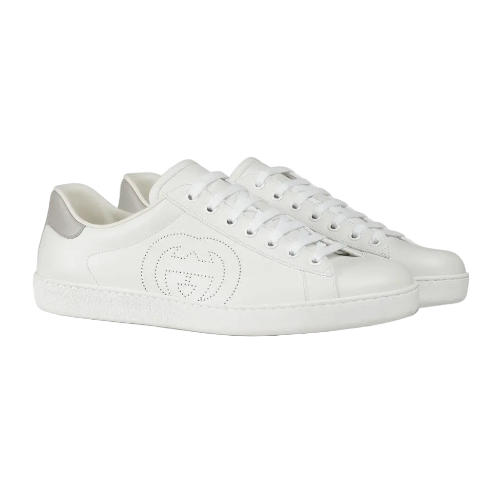 White sneakers with a brand logo on a light gray background