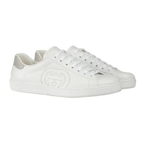 White sneakers with a brand logo on a light gray background