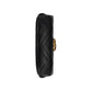 Black quilted clutch bag with gold hardware on a light gray background
