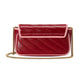 Red quilted handbag with a gold chain on a light gray background