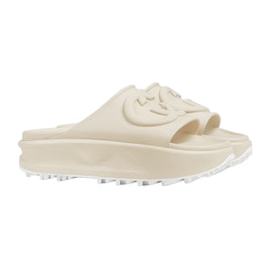 Beige slide sandal with a brand logo on a light gray background