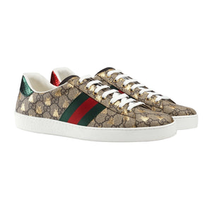 Gucci sneakers with patterned design and iconic red and green stripe on a light gray background