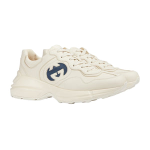 White sneaker with a blue logo on a light gray background