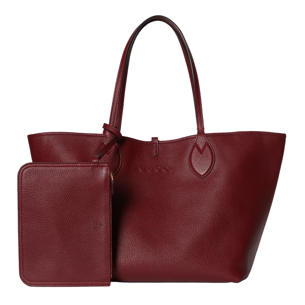 Red leather tote bag with matching wallet on a light gray background