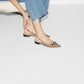 Person wearing patterned flats on a white background