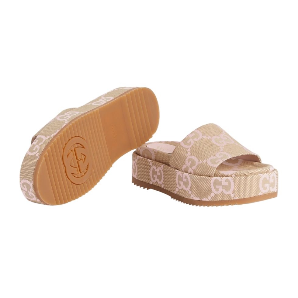 Beige platform sandals with logo pattern on a light gray background