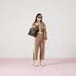 Person wearing a Gucci tracksuit with a handbag on a white background