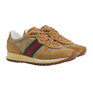 Tan sneakers with a red and green stripe on a light gray background