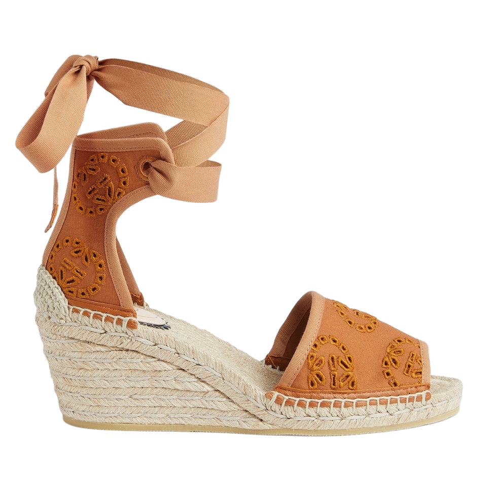 Brown wedge sandal with espadrille sole on a light gray background