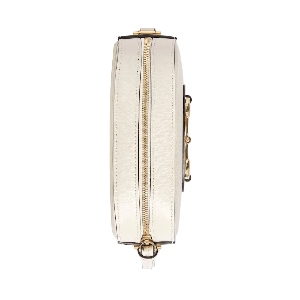 White wallet with gold zipper and accents on a light gray background