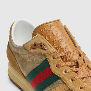 Tan sneaker with Gucci logo and green and red stripe on a light gray background