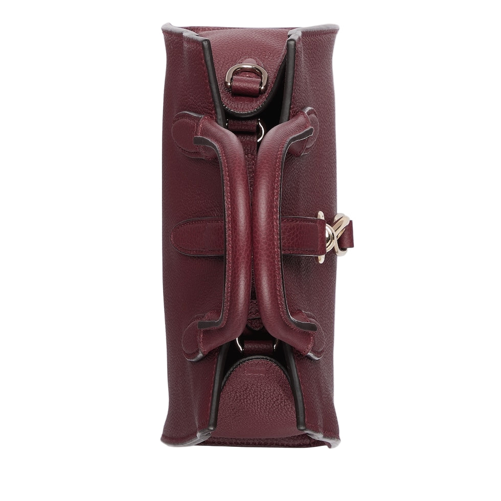 Maroon leather clutch bag with gold accents on a light gray background