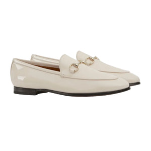 Pair of white loafers with gold accents on a light gray background