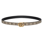 Designer belt with gold buckle on a light gray background