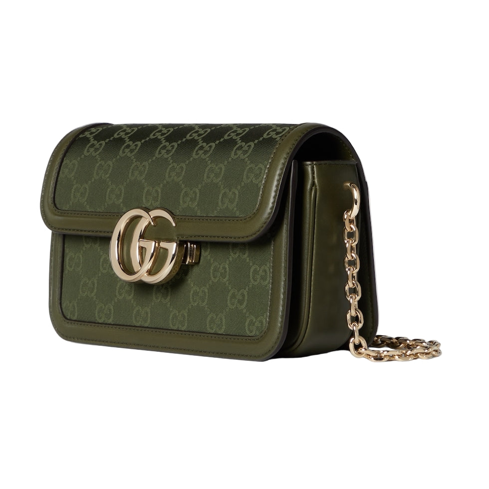 Green handbag with gold chain and logo on a light gray background