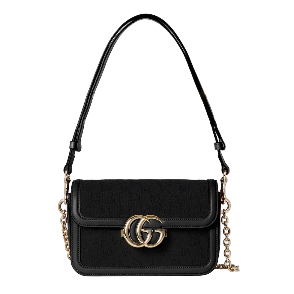 Black handbag with gold chain and logo on a light gray background