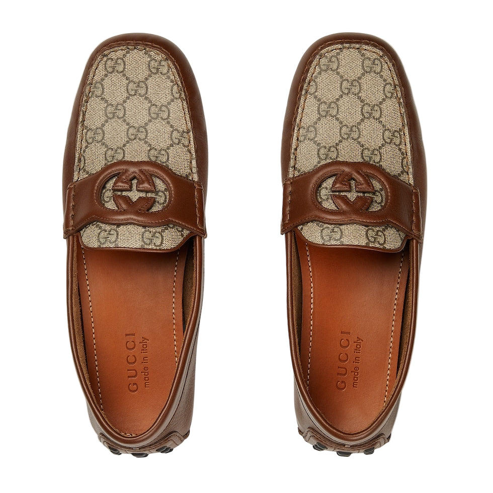 Pair of Gucci loafers with patterned strap on a white background