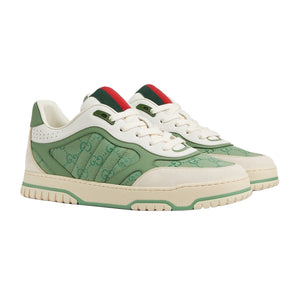 Green and white sneakers with red accents on a light gray background