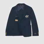 Navy blue blazer with Gucci logo on a light gray background