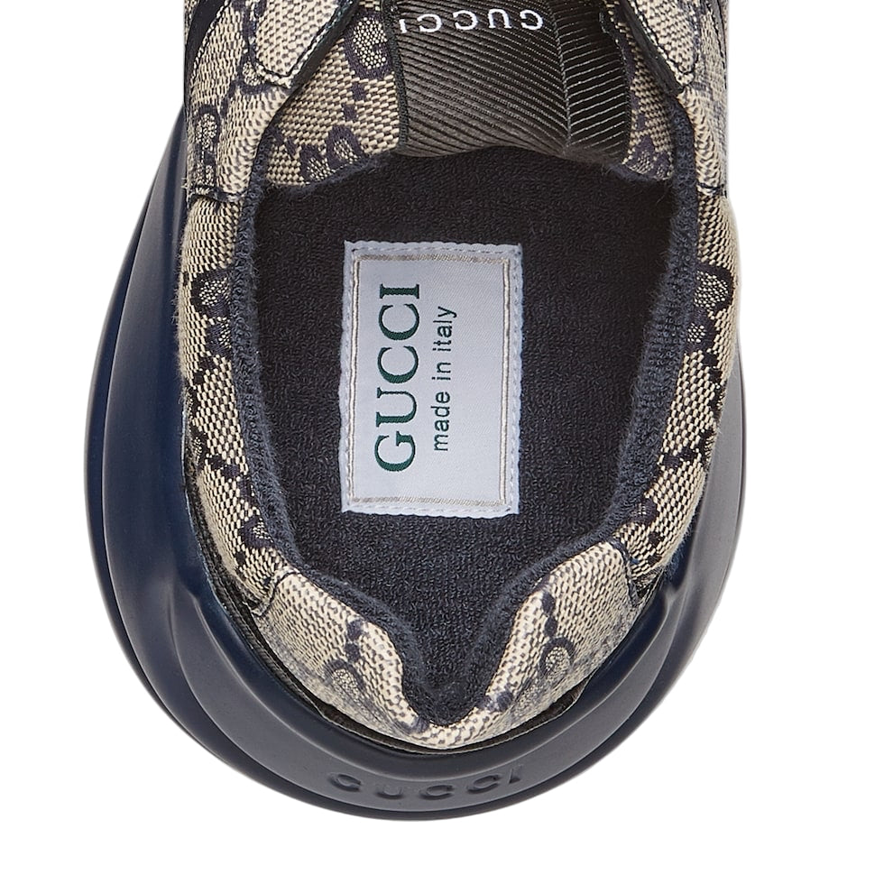 Gucci sneaker with patterned side and visible brand label on a light gray background