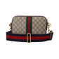 Designer handbag with patterned surface and colorful strap on a light gray background