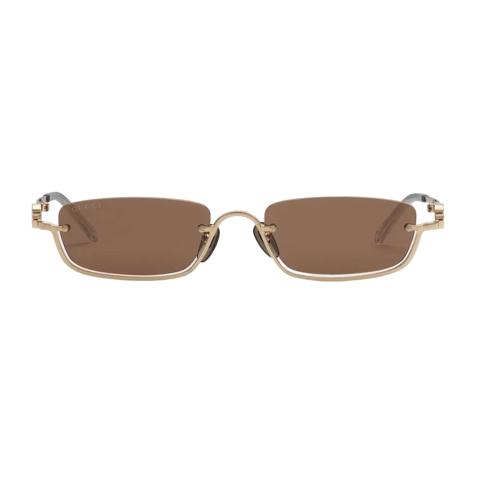 Sunglasses with gold frame and brown lenses on a light gray background