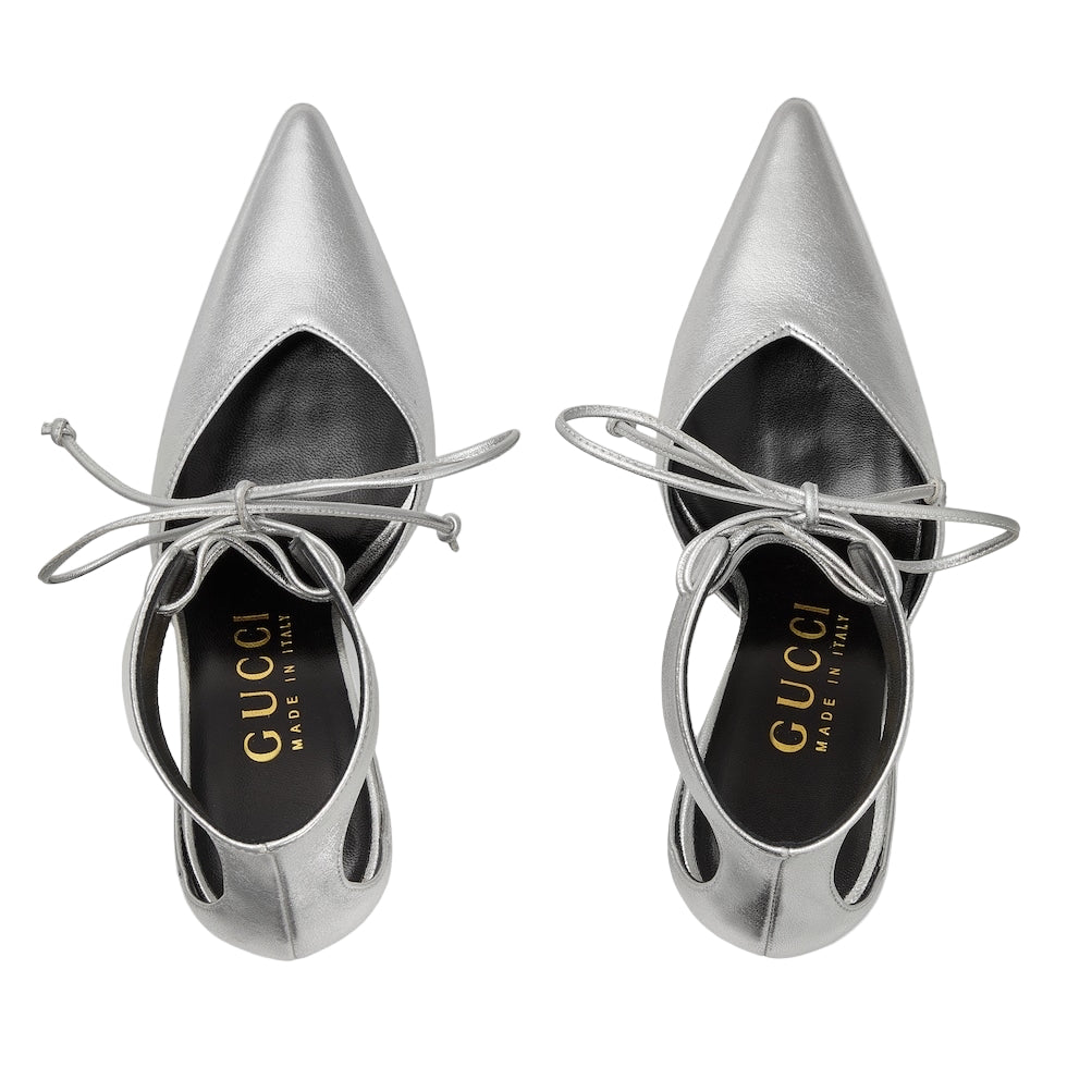 Pair of silver Gucci shoes with cut-out design on a light gray background