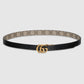 Black belt with beige pattern and gold buckle on a light gray background