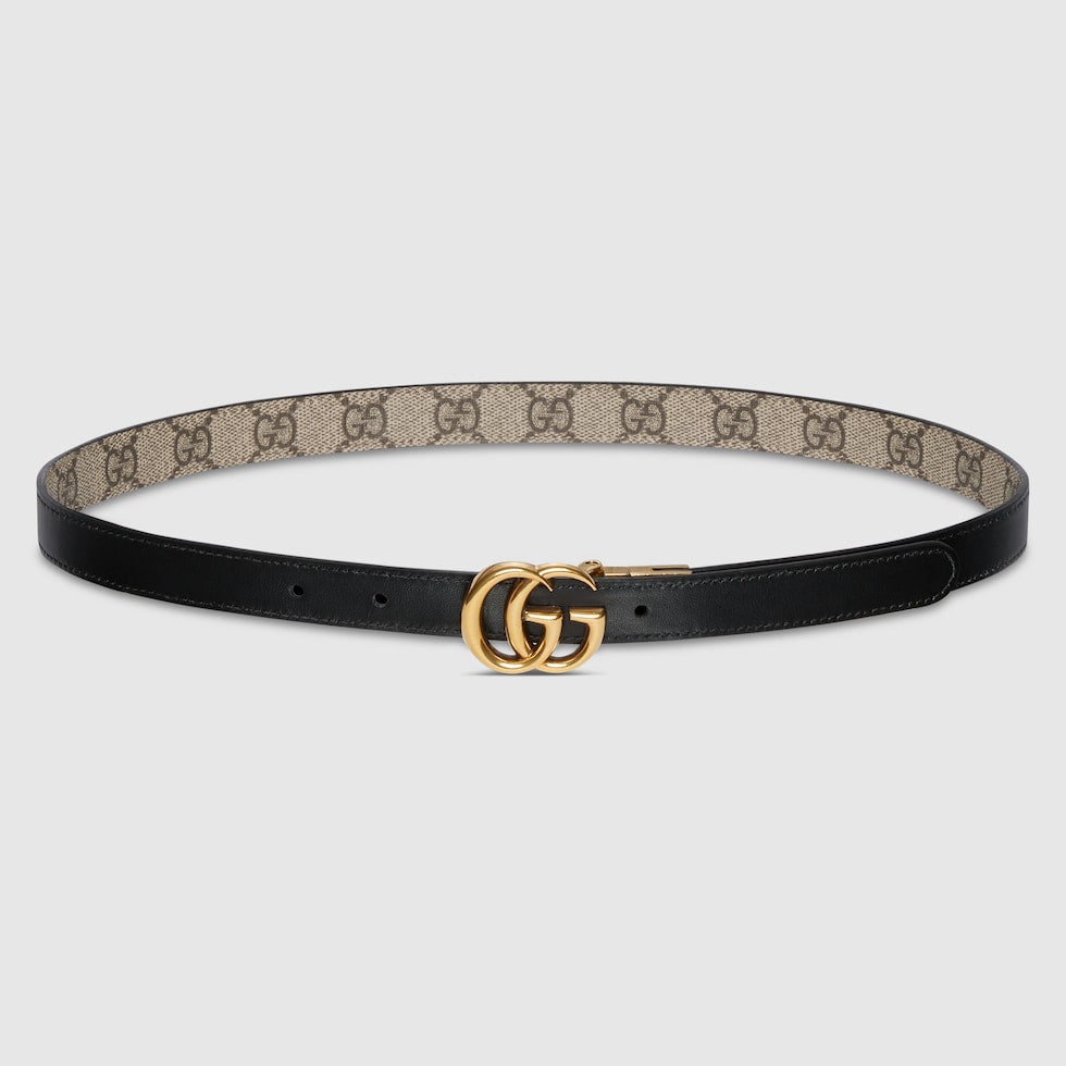 Black belt with beige pattern and gold buckle on a light gray background
