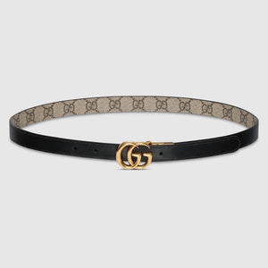 Black belt with beige pattern and gold buckle on a light gray background