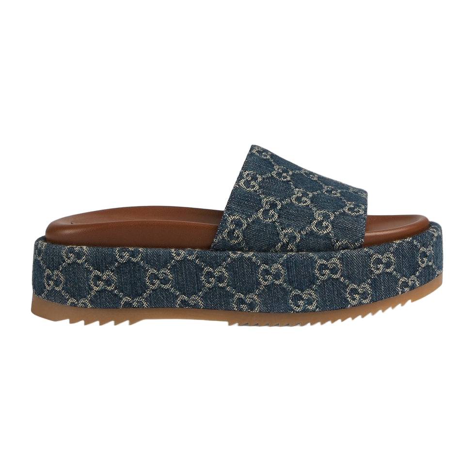 Blue denim slide sandal with brown sole on a light gray background