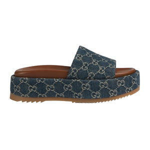 Blue denim slide sandal with brown sole on a light gray background